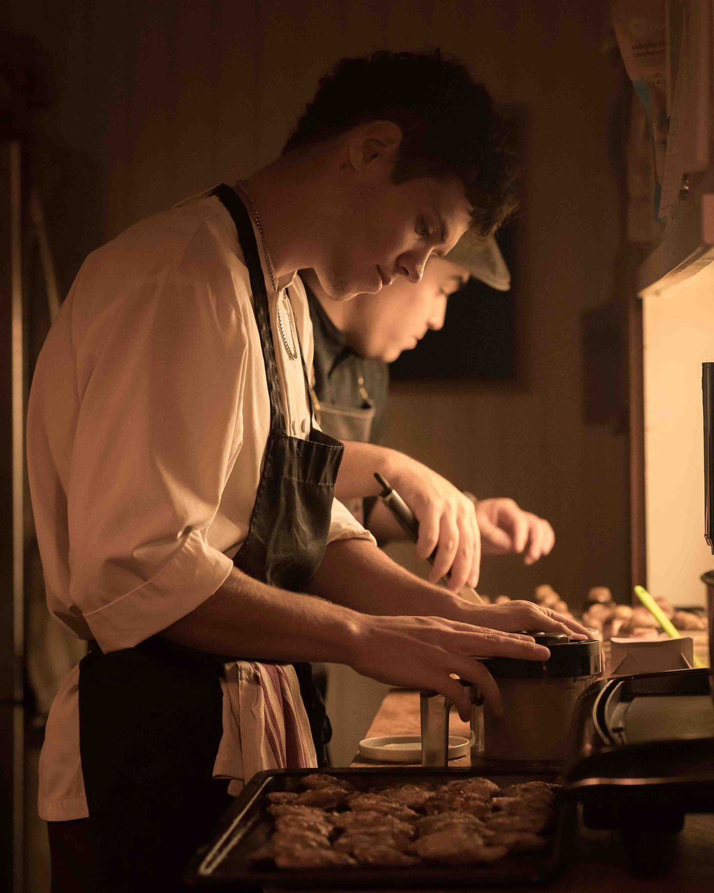 Chef Polka and his team cooking in a dimly lit kitchen