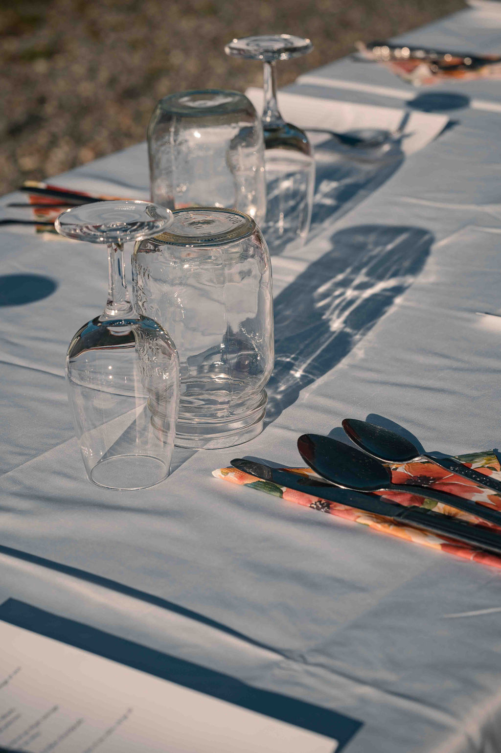 Table set with wine glasses, cutlery and floral napkins